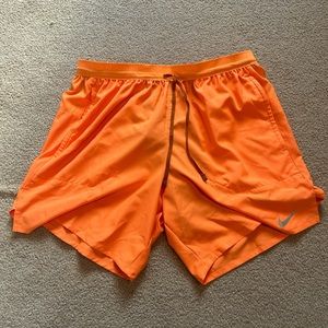 Orange Nike running shorts